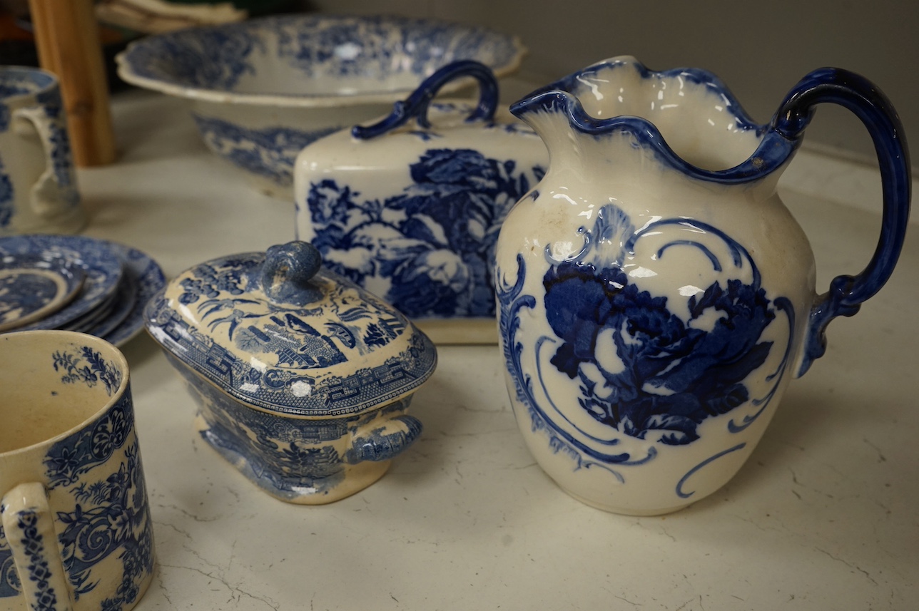 A group of blue and white ceramics to include Ironstone cheese dome and jug, a basin and twin handled cups, largest 36cm in diameter. Condition - varies